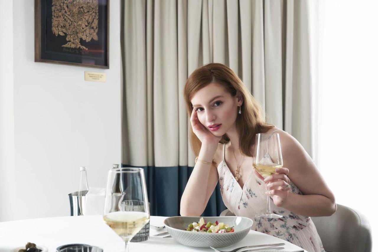 Athens Capital Center Hotel - Mgallery Collection Esterno foto A woman with a glass of wine